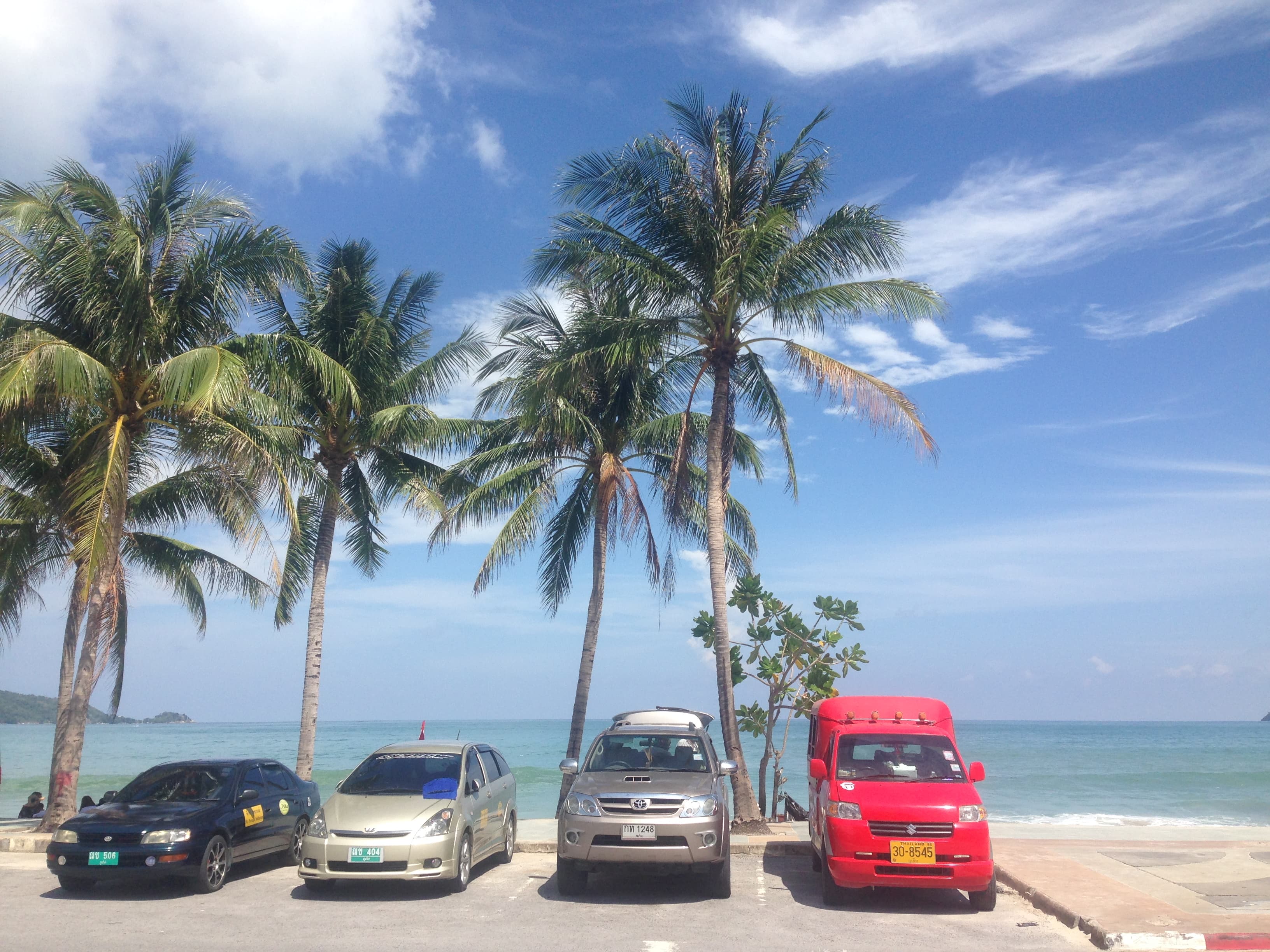 Phuket beach with turquoise water and palm trees.