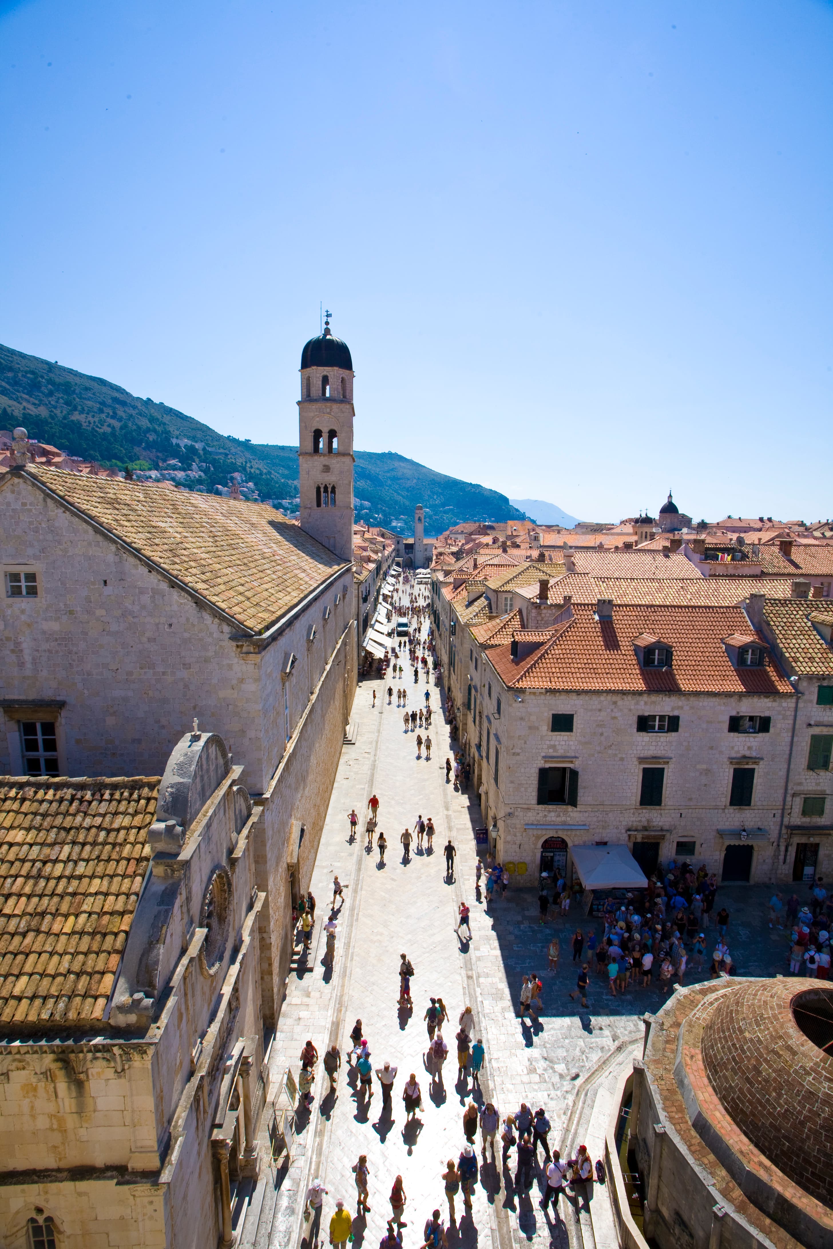 Historic old town of Dubrovnik with stone buildings and red roofs overlooking the Adriatic Sea.
